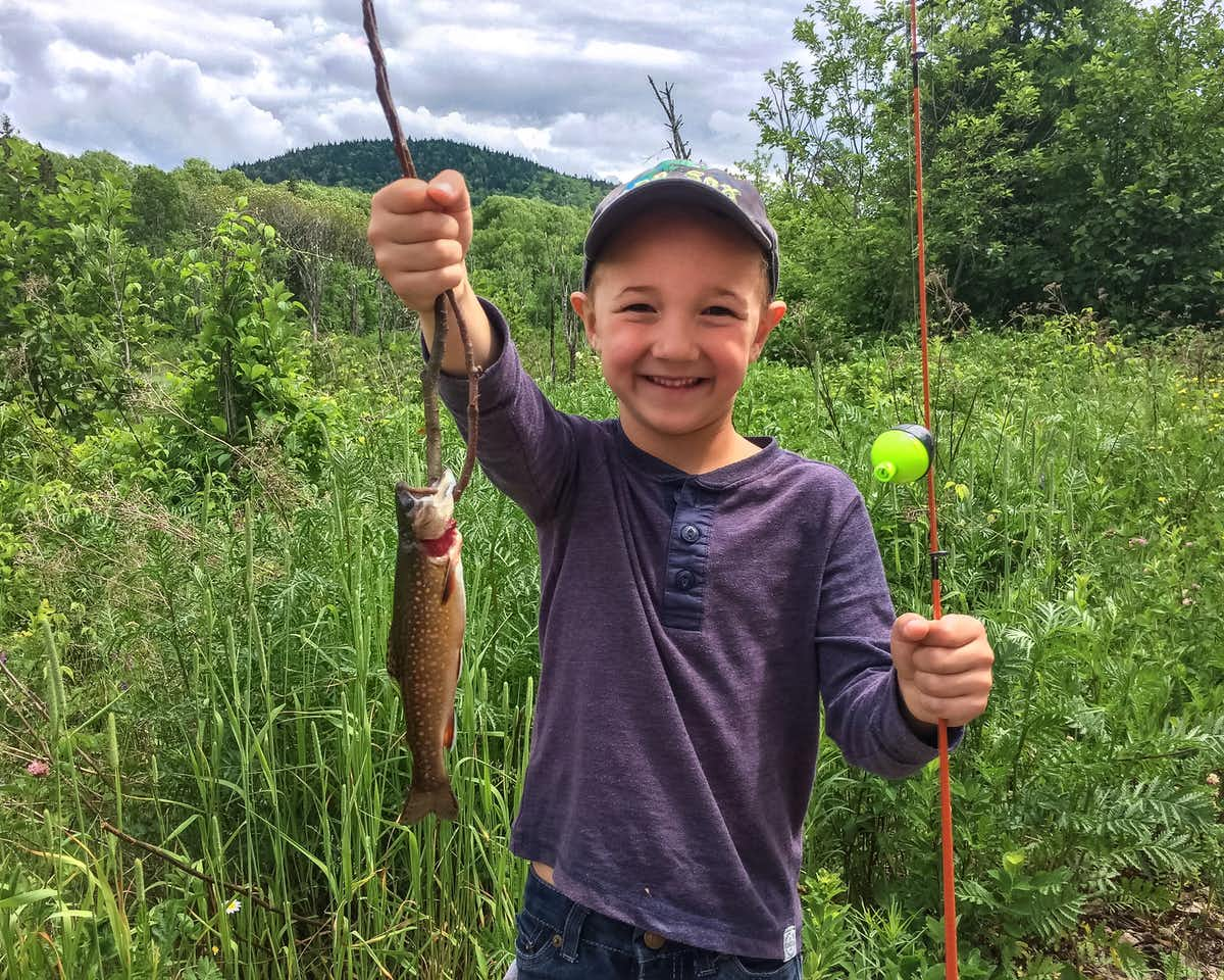 young smiling child holding up fish